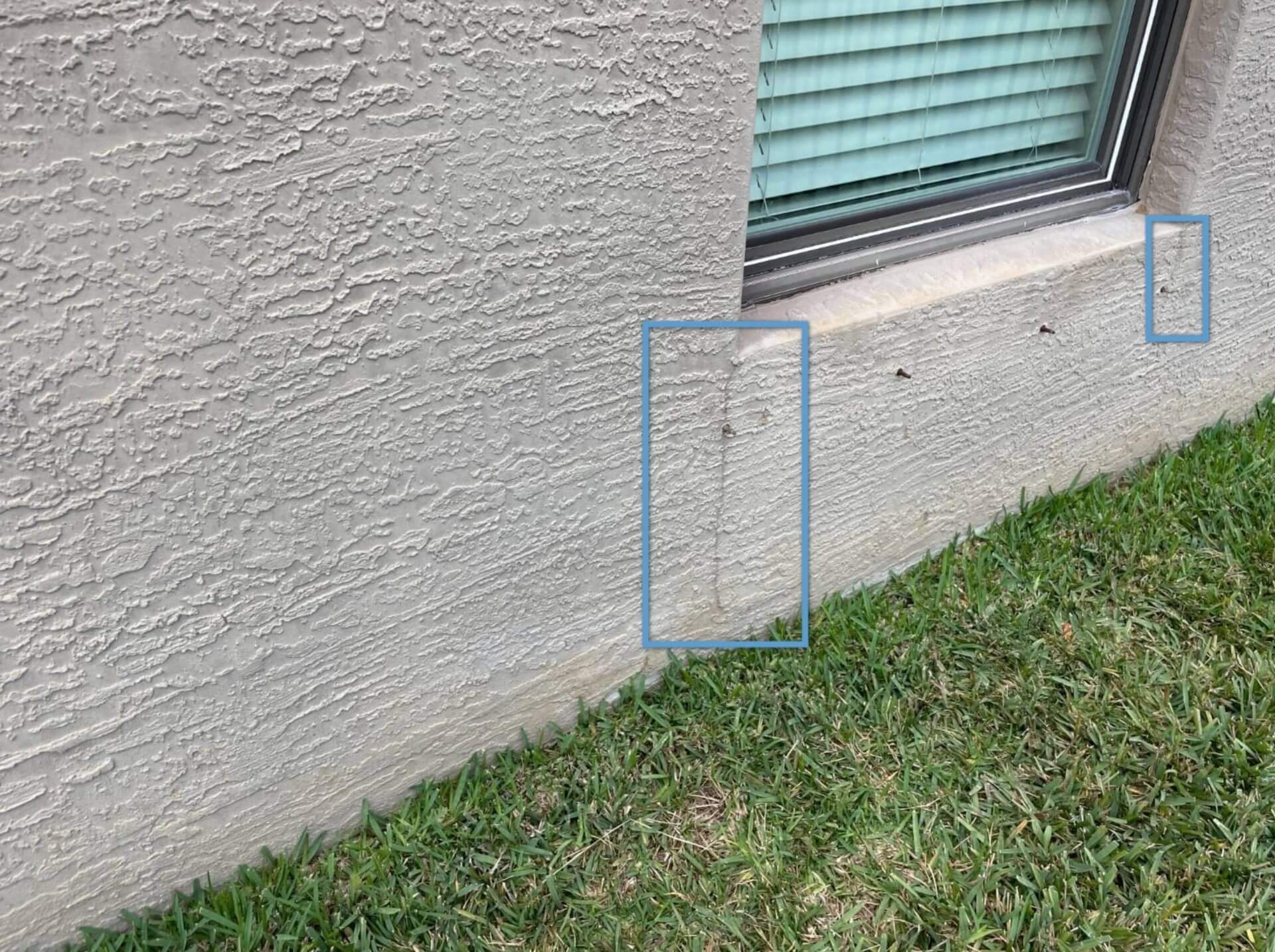 Cracked stucco on exterior of home with boxes pointing out where the cracks are